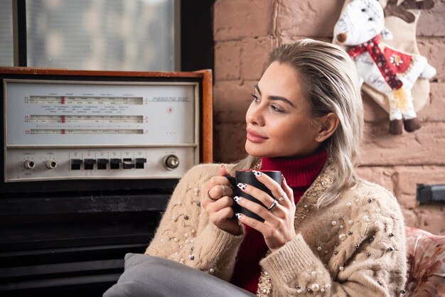 Een vrouw die wegkijkt en koffie drinkt