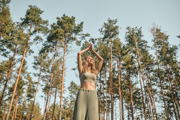 Een vrouw die yoga beoefent in het park en er betrokken uitziet