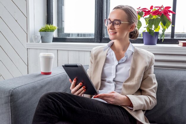 Een vrouw in brillen werken met tablet pc.