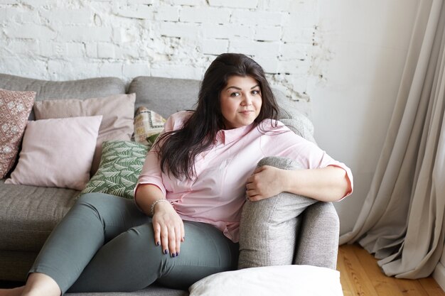 Een vrouw met een mooi lichaam poseren op de bank