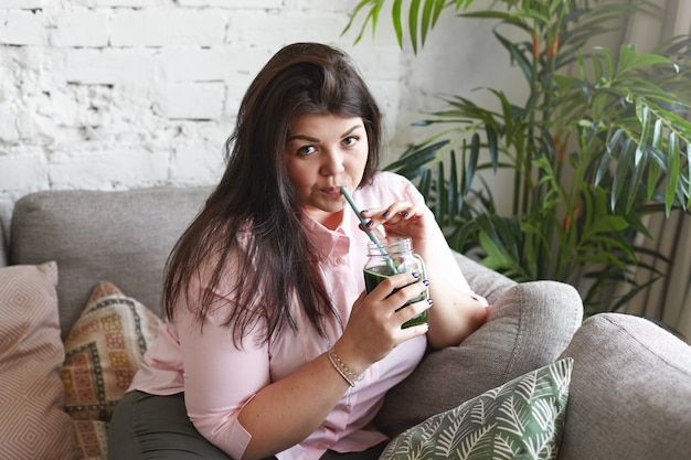 Een vrouw met een mooi lichaam poseren op de bank