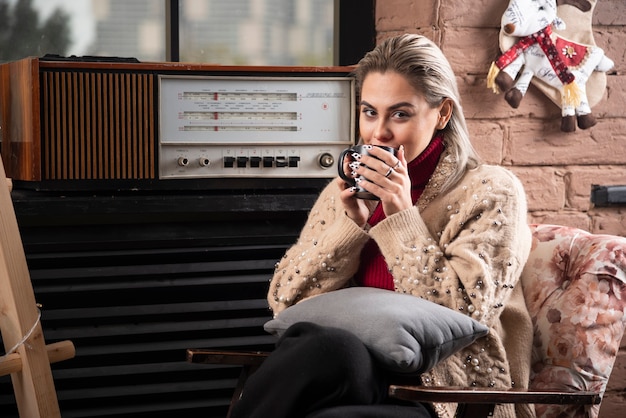 Een vrouw zit en drinkt koffie