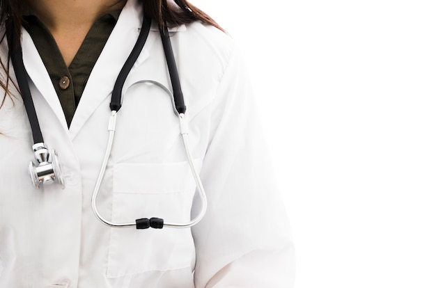 Een vrouwelijke arts met een stethoscoop om haar nek tegen een witte achtergrond