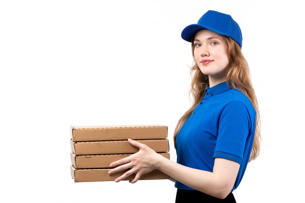 Een vrouwelijke werknemer van de vooraanzicht jonge vrouwelijke koerier van van de de leveringsdienst van de voedsellevering de dozen van de de pizzalevering op wit