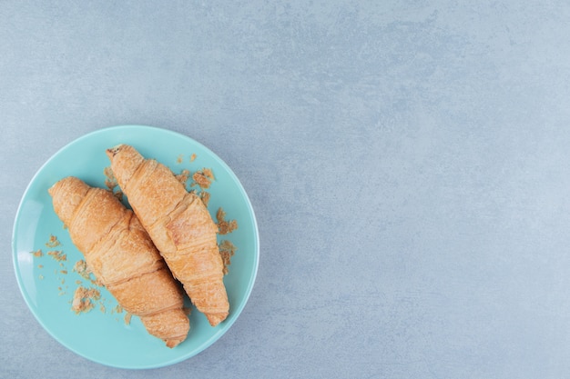 Een weergave van croissant op plaat op de marmeren achtergrond. hoge kwaliteit foto