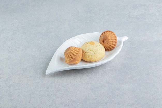 Een wit bord vol zoete heerlijke koekjes met suiker.