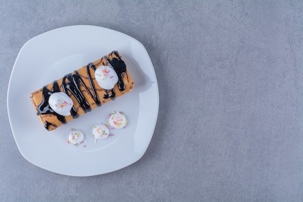 Een witte plaat van zoet heerlijk broodje met chocoladesiroop.