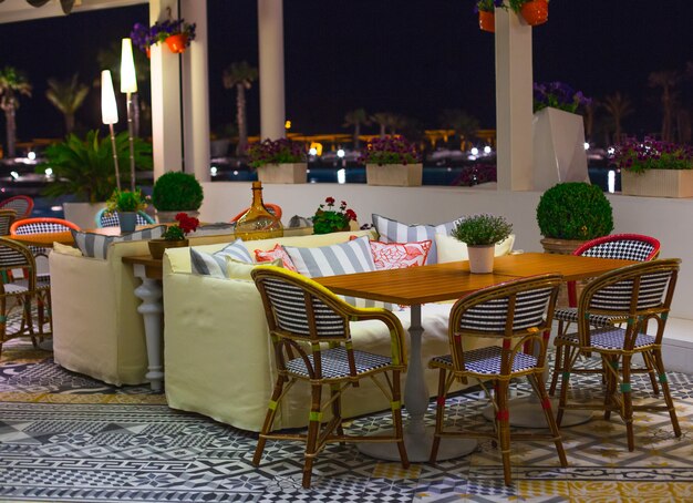 Een zittafel met stoelen en gele bank in een restaurant met panoramisch uitzicht.