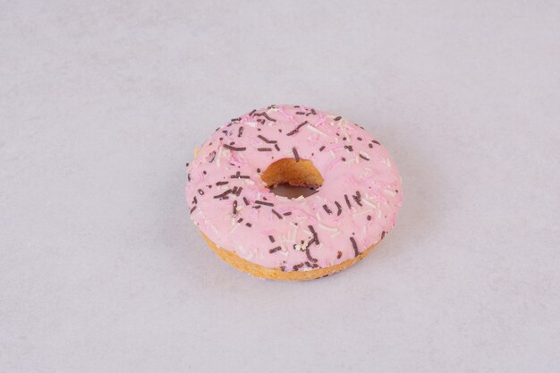 Een zoete roze doughnut op wit oppervlak