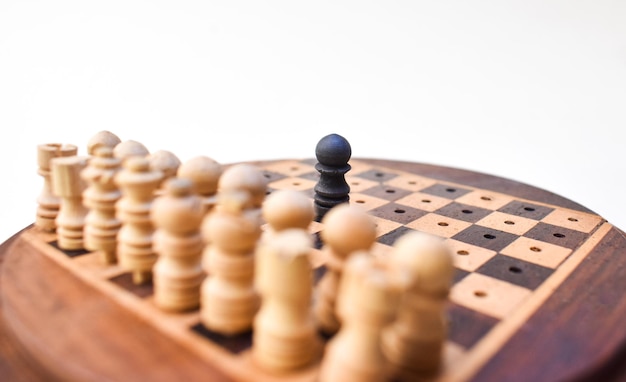 Één zwart schaakstuk tegen al concept van concurrentie houten schaakbord als achtergrond