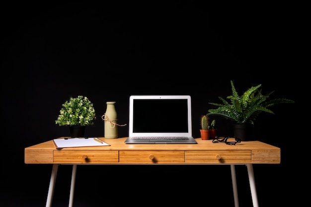 Eenvoudig houten bureau met grijze laptop