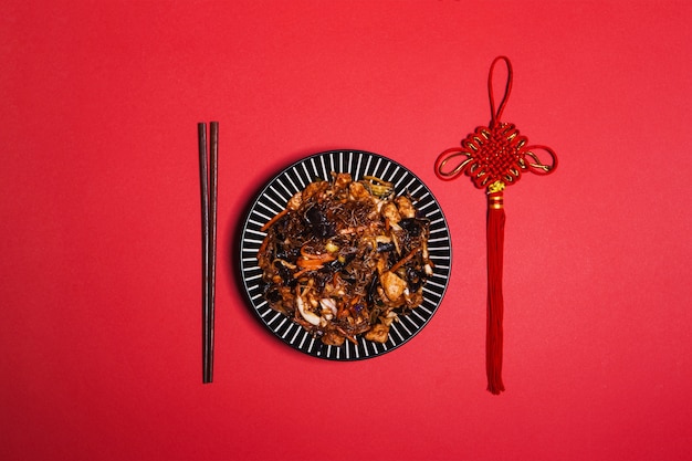 Eetstokjes en decoratie dichtbij Aziatisch voedsel