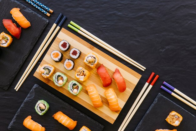 Eetstokjes in de buurt van sushi op planken