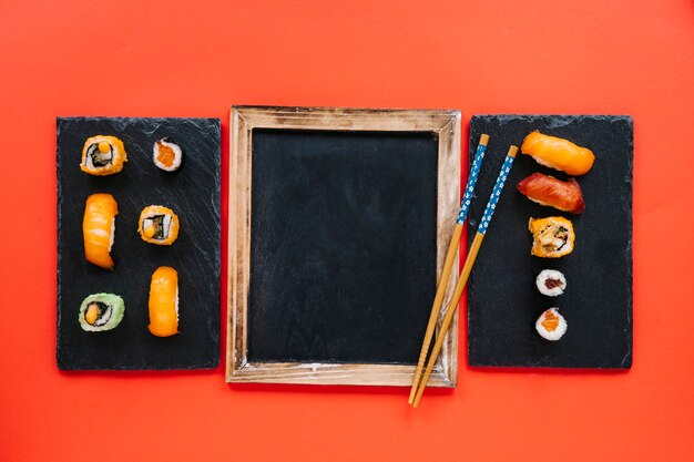 Eetstokjes op blackboard tussen sushi boards