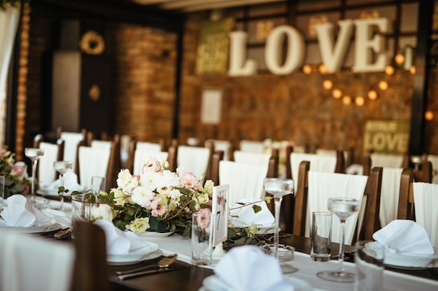 Eettafel met bloemen middelpunt bij huwelijksreceptie.