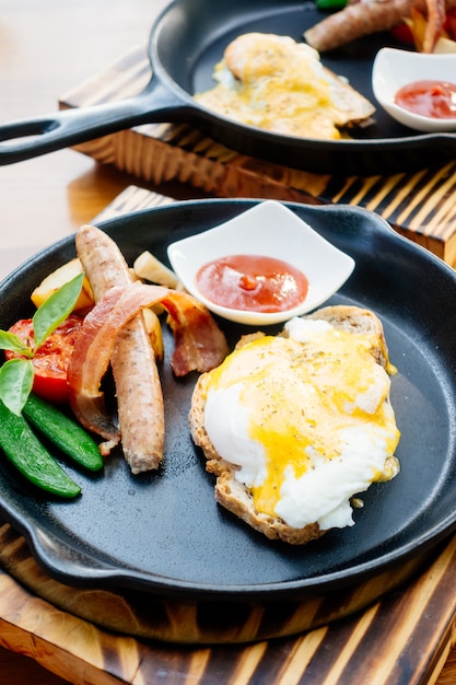 Ei benedict met worstspek en tomatensaus