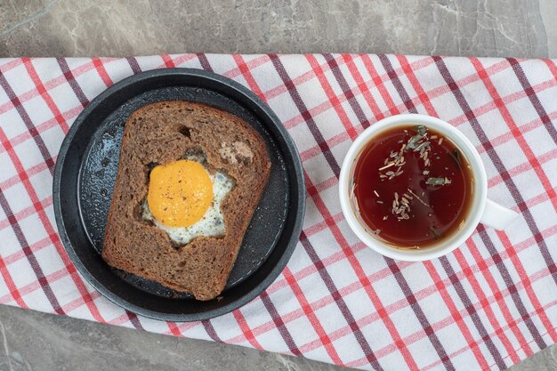 Ei toast brood en kopje thee op tafellaken. Hoge kwaliteit foto