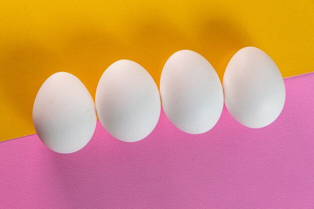 Eieren op de gele en roze tafel