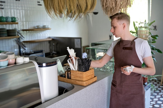 Gratis foto eigenaar van een kleine onderneming die coffeeshop opruimt