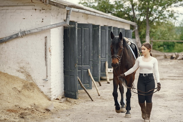 Gratis foto elegant meisje in een boerderij met een paard