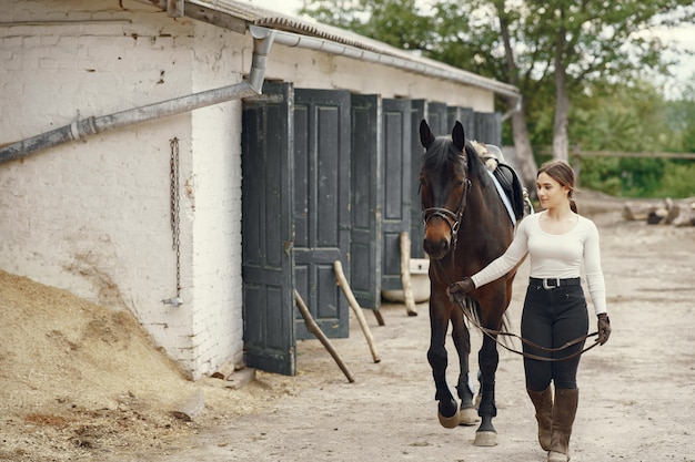 Elegant meisje in een boerderij met een paard