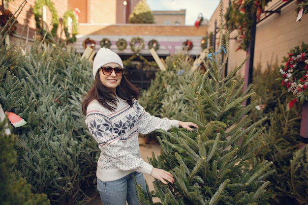 Elegant meisje koopt een kerstboom.