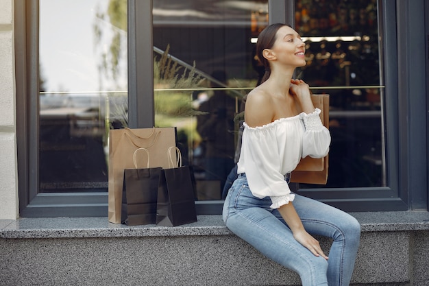 Gratis foto elegante en stijlvolle meisjes op straat met boodschappentassen