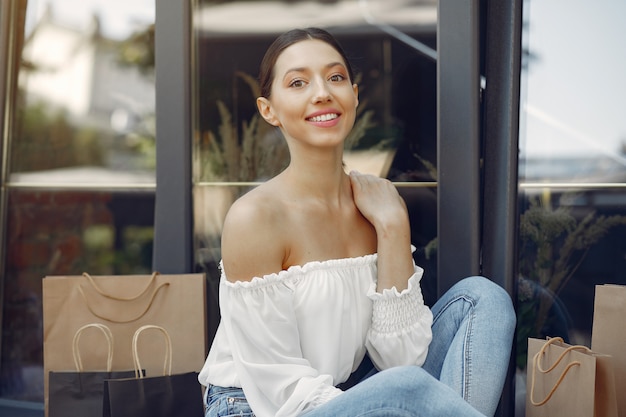 Gratis foto elegante en stijlvolle meisjes op straat met boodschappentassen