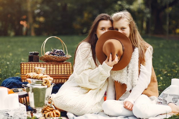 Elegante en stijlvolle meisjes zitten in een herfst park