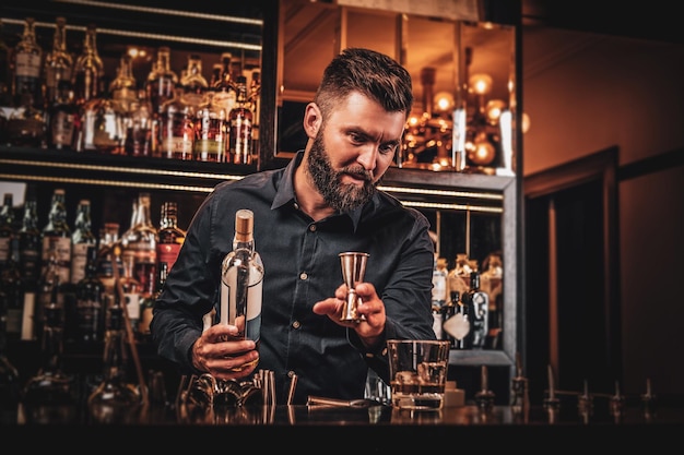 Elegante happy bar-eigenaar maakt speciaal drankje voor zijn klanten in zijn eigen bar.