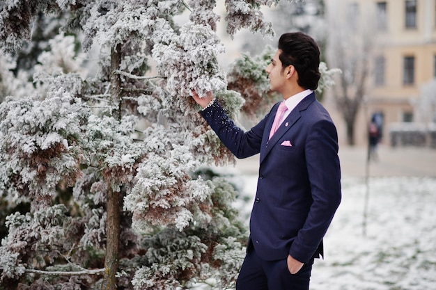 Elegante Indiase macho man model op pak en roze stropdas geposeerd op winterdag