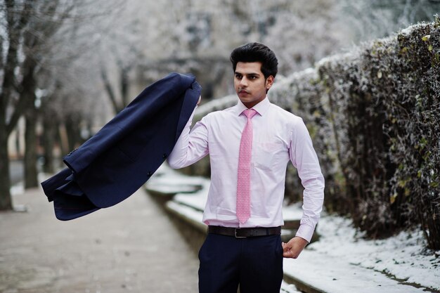 Elegante Indiase macho man model op pak en roze stropdas geposeerd op winterdag