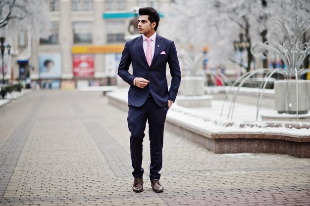 Elegante Indiase macho man model op pak en roze stropdas geposeerd op winterdag