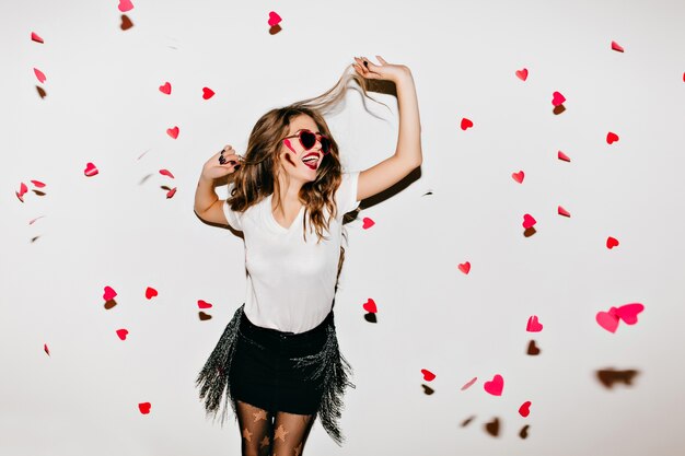 Elegante jonge dame in trendy zonnebril kijken naar gevallen harten