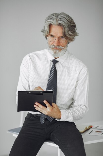 Elegante man in kantoor. Zakenman in wit overhemd. Man werkt met documenten.