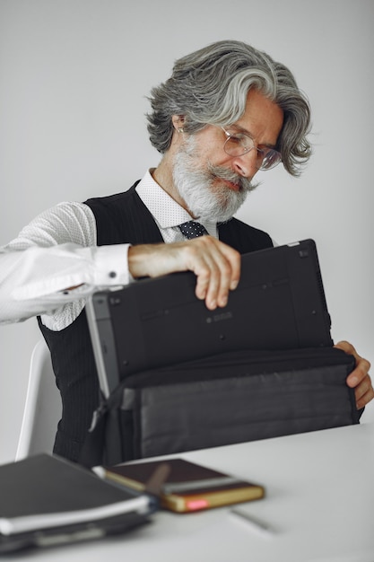 Elegante man in kantoor. Zakenman in wit overhemd. Man werkt met laptop.