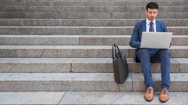 Elegante man met laptop op stappen