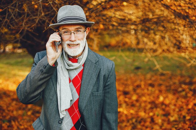 Elegante oude man in een zonnig herfstpark