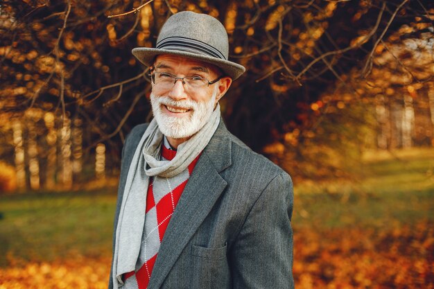 Elegante oude man in een zonnige herfst park