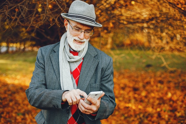 Elegante oude man in een zonnige herfst park