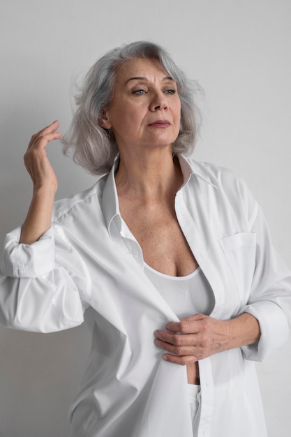 Gratis foto elegante oude vrouw die witte kleren draagt