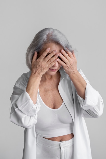 Elegante oude vrouw die witte kleren draagt