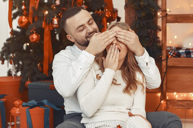 Elegante paar om thuis te zitten in de buurt van de kerstboom