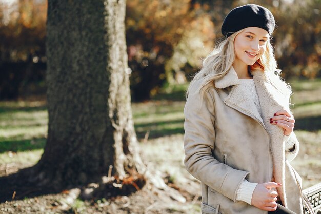 Elegante schattige blonde in een herfst stad