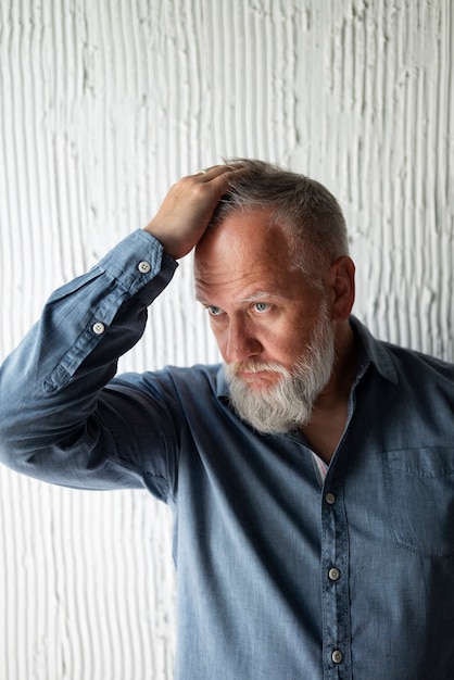 Elegante senior man poseren in blauw shirt