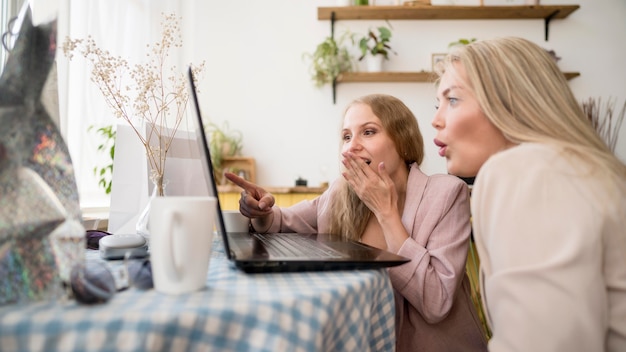 Elegante volwassen vrouwen die online winkelen