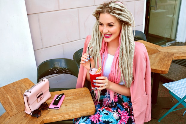 Gratis foto elegante vrouw die van haar berry smakelijke limonade op koffieterras geniet