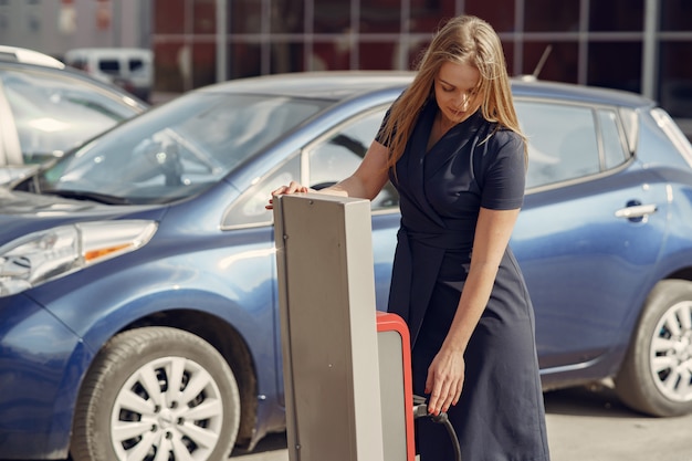 Gratis foto elegante vrouw die zich op een benzinestation bevindt