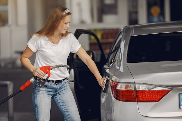 Elegante vrouw die zich op een benzinestation bevindt