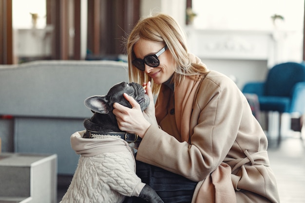 Elegante vrouw in een bruine jas met zwarte bulldog